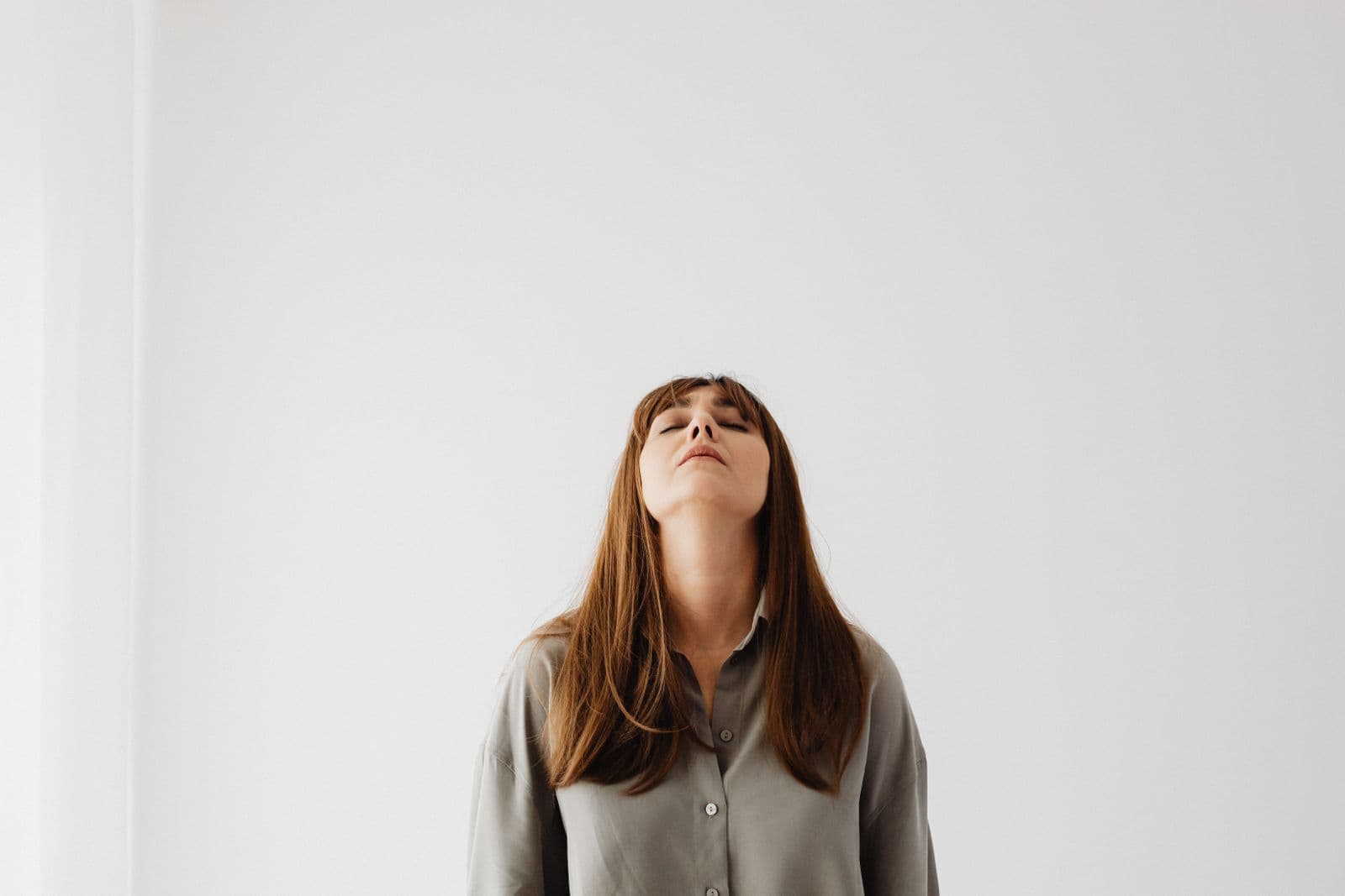 Person standing calmly against a pale wall