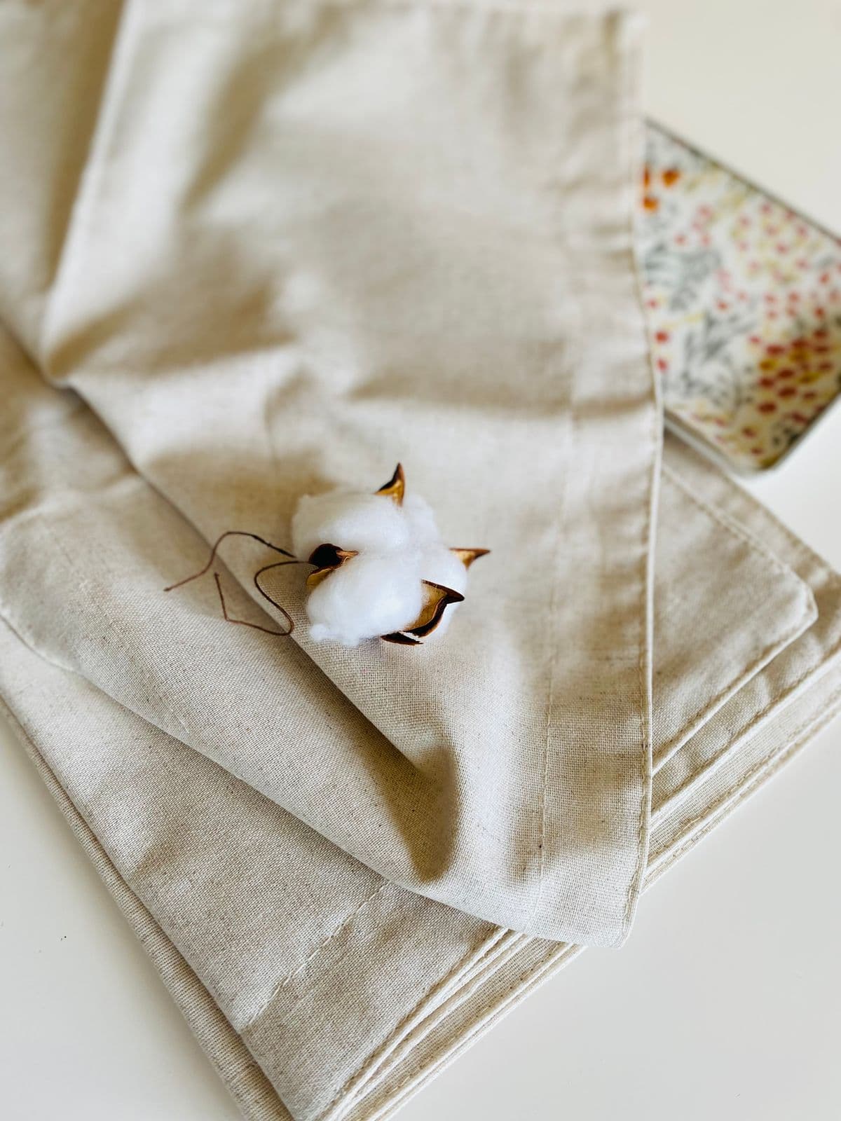 Cotton stem resting on folded natural linen